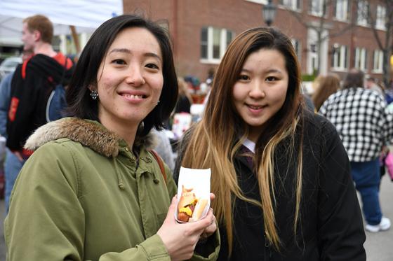 Two female students showing a hot dog at Hot Dog Day